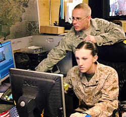 Marine Cpl. Kimberly Crawford, a combat correspondent stationed at Camp Lejuene, N.C., edits video with assistance from Air Force Staff Sgt. Jeff St. Sauveur at Bagram Airfield, Afghanistan, Feb. 14, 2009. U.S. Army photo by Spc. Matthew Thompson